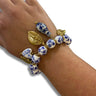 Bracelet with blue and white ceramic beads and gold accents on a wrist against a white background