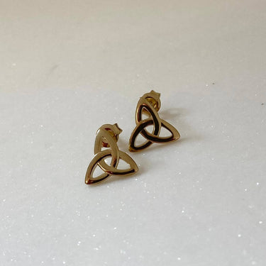 Gold Celtic knot earrings on a light gray background