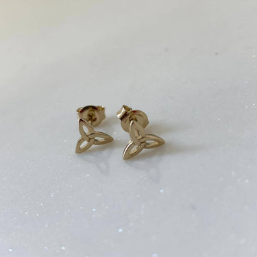Gold Trinity knot earrings on a light gray background