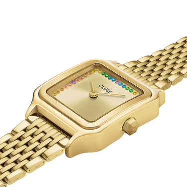 Gold wristwatch with a colorful face on a white background