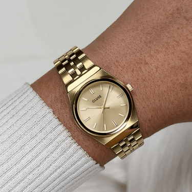 cluse small round face watch with gold link strap on ladies wrist