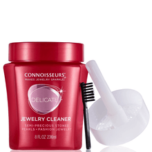 Red jewelry cleaner container with brush and funnel on a white background