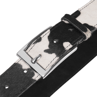 Black and white cowhide leather belt with silver buckle on a white background