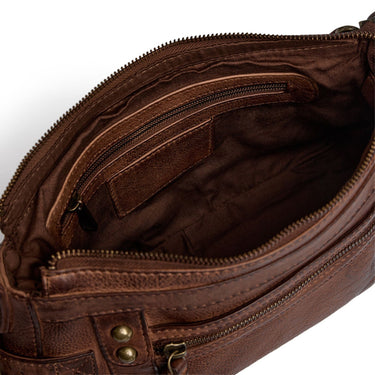 Close-up of the interior of a brown leather bag, showing a zippered compartment, interior pocket, and brass-tone hardware on a white background.