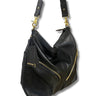 A black leather slouchy shoulder bag with gold-tone hardware, featuring a detachable shoulder strap, gold zippers, and a black brand tag with 'DEPECHE' printed in gold on a white background.