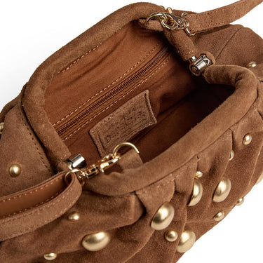 Brown suede handbag with gold studs and a visible brand label on a white background