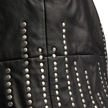Close-up of a black leather garment, likely a skirt or jacket, featuring vertical rows of silver metal studs on a white background.