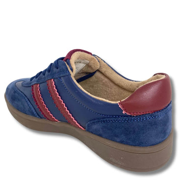A blue suede and leather low-top sneaker with red wavy side stripes, a red heel tab, and a tan fleece lining, shown from a three-quarters angle on a white background.