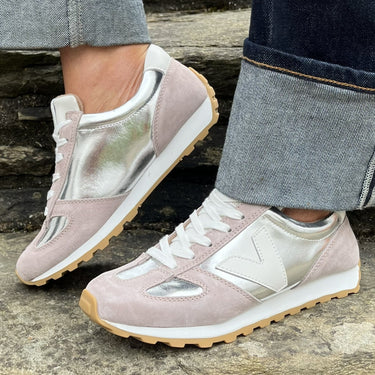 Person wearing light pink sneakers with a neutral background