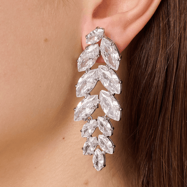 Close-up of a woman wearing a sparkling earring with clear gemstones.