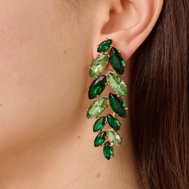 Green gemstone earring worn by a person