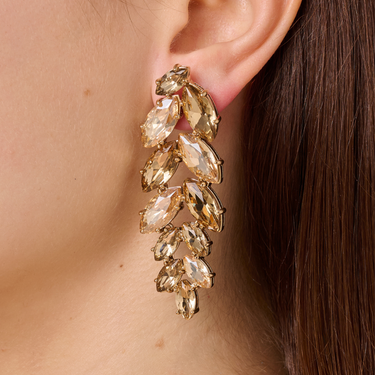 Gold earrings with clear stones worn by a person