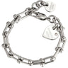 A silver chain bracelet with a lobster clasp, featuring a heart-shaped charm engraved with 'DYRBERG KERN' and a small clear rhinestone, alongside a round tag with the same branding.