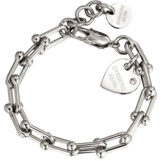 A silver chain bracelet with a lobster clasp, featuring a heart-shaped charm engraved with 'DYRBERG KERN' and a small clear rhinestone, alongside a round tag with the same branding.