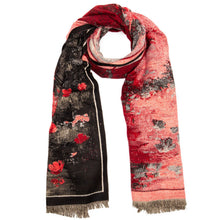A patterned scarf with a split design, featuring a black side with red floral motifs and a coral-pink side with a distressed abstract texture, finished with fringed ends.