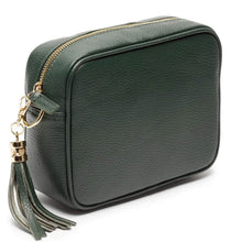 A dark green pebbled leather camera bag with a gold zipper and a matching green leather tassel charm with gold hardware, shown on a white background.