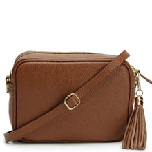A brown pebbled leather crossbody bag with a gold-tone buckle and a matching leather tassel charm, shown on a plain white background.