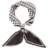 A black and white patterned scarf tied in a knot, featuring a houndstooth-like geometric print on the top loop and solid black pointed ends with white borders.