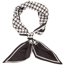 A black and white patterned scarf tied in a knot, featuring a houndstooth-like geometric print on the top loop and solid black pointed ends with white borders.