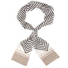 A lightweight scarf with a black and white geometric pattern, featuring chevron and stripe designs and solid beige ends, displayed on a clean white background.