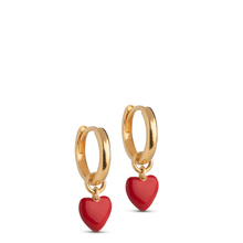 Gold hoop earrings with red heart charms on a white background