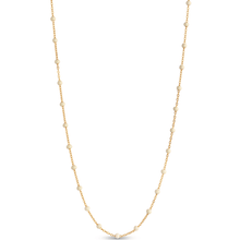 Gold necklace with small beads on a white background
