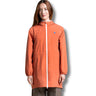 Person wearing an orange raincoat with a brand logo on a white background