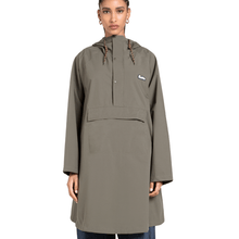 Person wearing a green raincoat with a brand logo on a white background