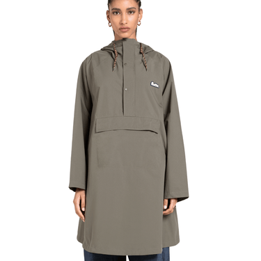 Person wearing a green raincoat with a brand logo on a white background