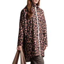 Person wearing a leopard print raincoat with a visible brand logo on a white background