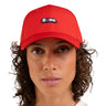 A close-up of a person wearing a bright red baseball cap with a small embroidered 'flotte.' logo patch on the front, against a plain white background.