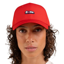 A close-up of a person wearing a bright red baseball cap with a small embroidered 'flotte.' logo patch on the front, against a plain white background.