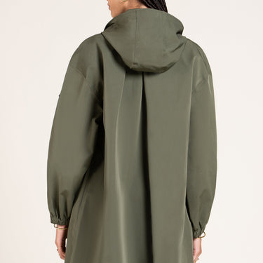 Person wearing a green raincoat on a plain background