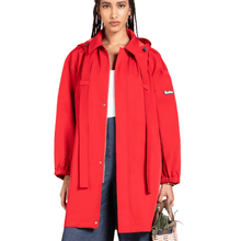 Person wearing a red raincoat with a brand logo on a white background