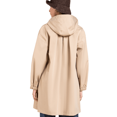 Beige raincoat worn by a person on a white background