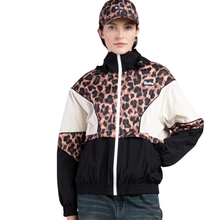 Person wearing a leopard print and black jacket with a white zipper on a white background