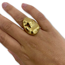 Gold ring on a person's finger against a white background