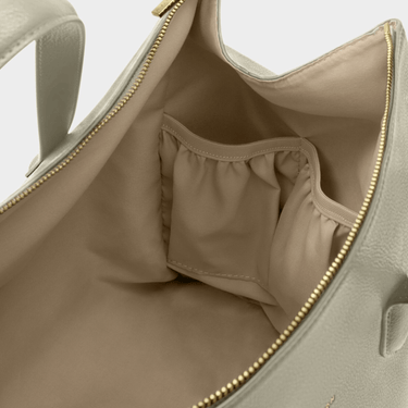 Close-up of a pale green bag with gold zipper details