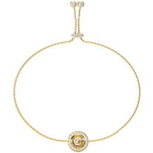 Gold bracelet with a circular clasp on a white background