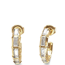 A pair of gold huggie hoop earrings with baguette-cut clear gemstones, shown on a plain white background.