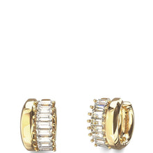 A pair of gold huggie hoop earrings with a row of clear baguette-cut stones on the front, shown from side and back angles against a solid white background.