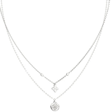 A delicate double-layered silver necklace featuring a fine chain with a small clover-shaped charm and a longer chain with a round medallion pendant, shown on a plain white background.