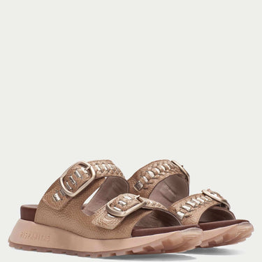 Pair of brown sandals with decorative straps on a light beige background