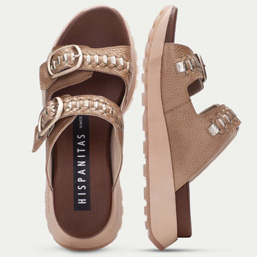 Pair of brown sandals with embellishments on a light gray background
