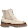 A single cream-colored leather Chelsea boot with a brown lug sole, shown from a side profile on a white background.