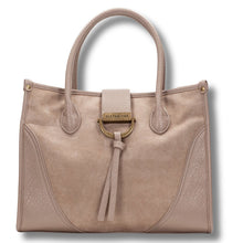 A light taupe faux-leather handbag with dual top handles, a front flap, and a gold-tone ring detail with a tassel, shown on a white background.