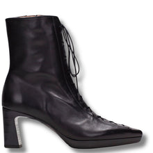 A black leather ankle boot with a block heel, pointed toe, and lace-up front, shown from a side profile on a white background.