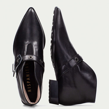 Black leather shoes with a strap on a light gray background