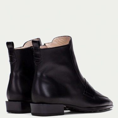 Pair of black leather ankle boots on a light gray background