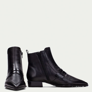 Pair of black leather ankle boots on a light gray background